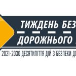 Жовтий дорожній знак із цифрою «7» на фоні темної смуги з написом «Тиждень безпеки дорожнього руху». Нижче зазначено: «2021–2030 Десятиліття дій з безпеки дорожнього руху».