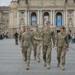 Фото на якому молоді люди у військовій формі йдуть вулицею.
