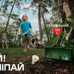 Дитина з бадмінтоном помічає небезпечний предмет на землі серед лісу. Напис: «Стій! Не чіпай. Телефонуй 101»