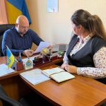 Чоловік за робочим столом спілкується з жінкою в кабінеті