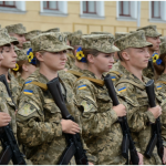 Українські військовослужбовці в камуфляжній формі шикуються на плацу з автоматами